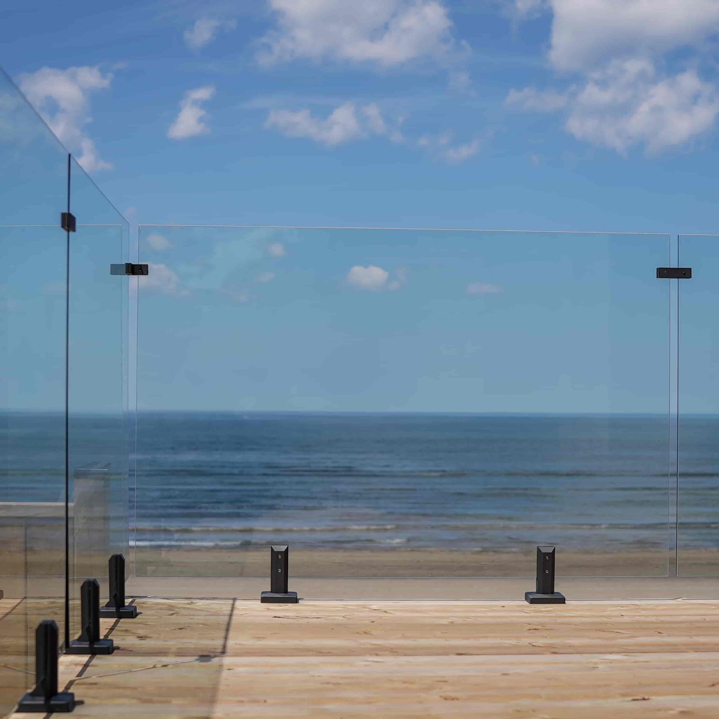 Modern frameless glass deck railing with ocean view